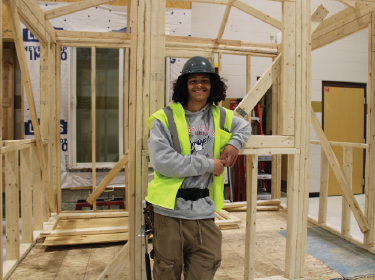 student wearing construction hat and vest